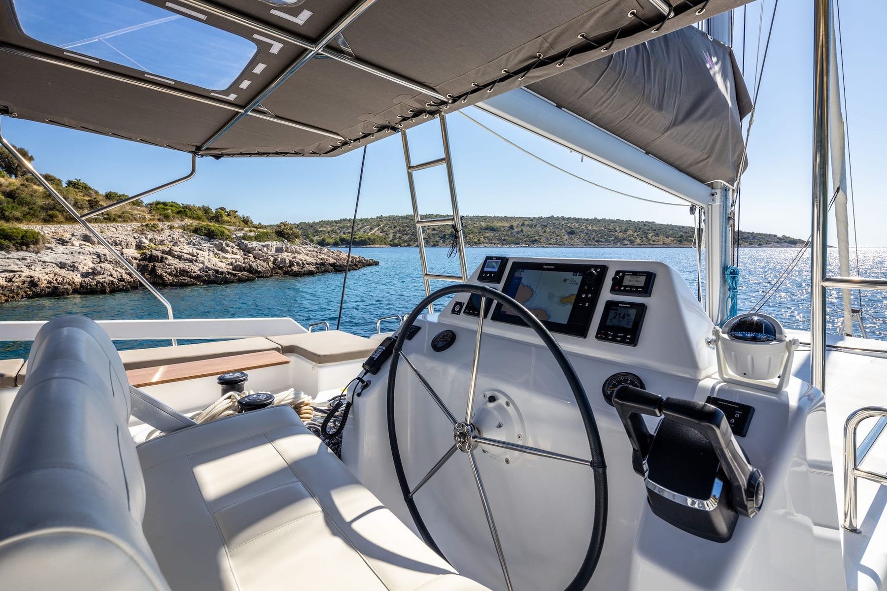 The flybridge helm station under its bimini